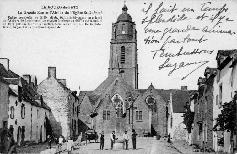 Image de la Grand'rue, du calvaire et de l'abside de l'église Saint-Guénolé au Bourg de Batz